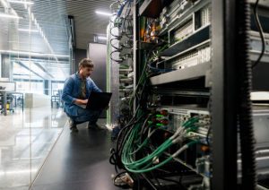 Técnico da DataRoad num corredor de datacenter junto a bastidores de rede