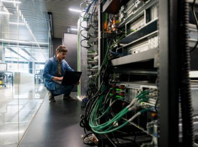 Técnico da DataRoad num corredor de datacenter junto a bastidores de rede